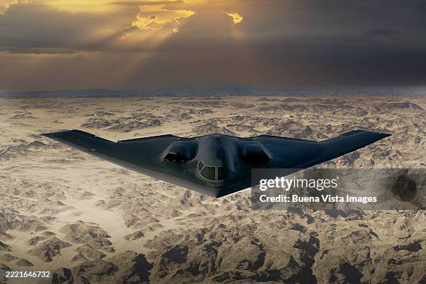 northrop grumman b-2 spirit flying over desert at sunset - stealth bomber foto e immagini stock