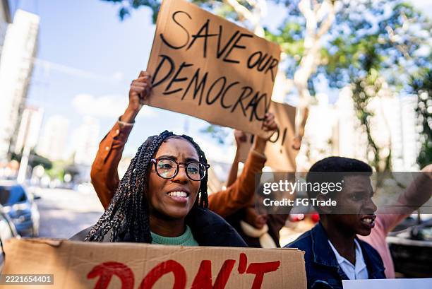 young woman protesting outdoors - democracy stock pictures, royalty-free photos & images