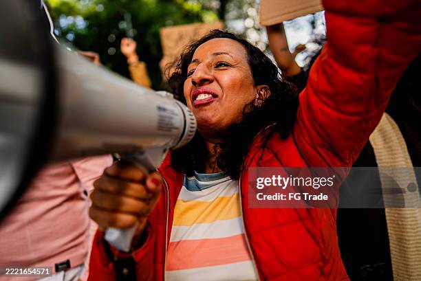 femme mûre manifestant à l’extérieur - justice sociale concept photos et images de collection