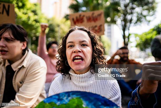 junge umweltschützerin bei protest - hautfarben stock-fotos und bilder