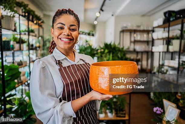 portrait of a shop owner holding a decorative vase at a home decor store - craft product stock pictures, royalty-free photos & images