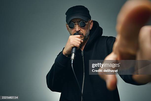 passionate musician singing into a microphone and pointing at you - rap stock pictures, royalty-free photos & images