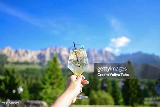 touriste tenant un spritz avec les montagnes des dolomites en arrière-plan - apéritif photos et images de collection
