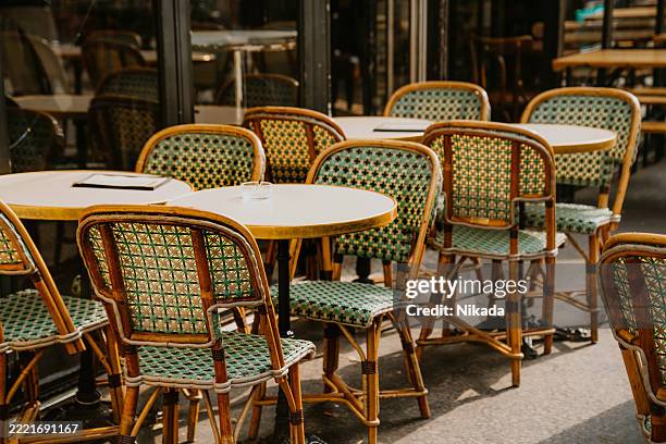 outdoor parisian café with bamboo chairs and tables in warm sunlight - woven fabric stock pictures, royalty-free photos & images