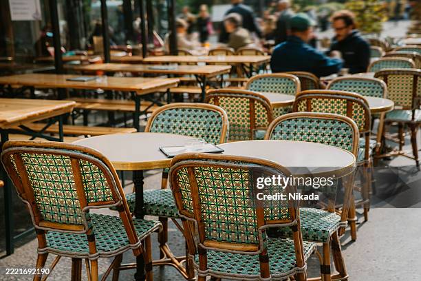 terrasse extérieure avec chaises tressées dans un café parisien par une journée ensoleillée - terrasse-de-café photos et images de collection