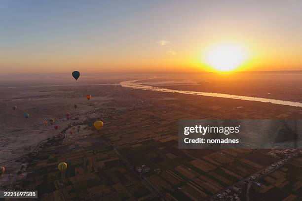 hot air balloon with sunrise flying over luxor city, recomend activity for egypt travel. - vanuit een heteluchtballon stockfoto's en -beelden