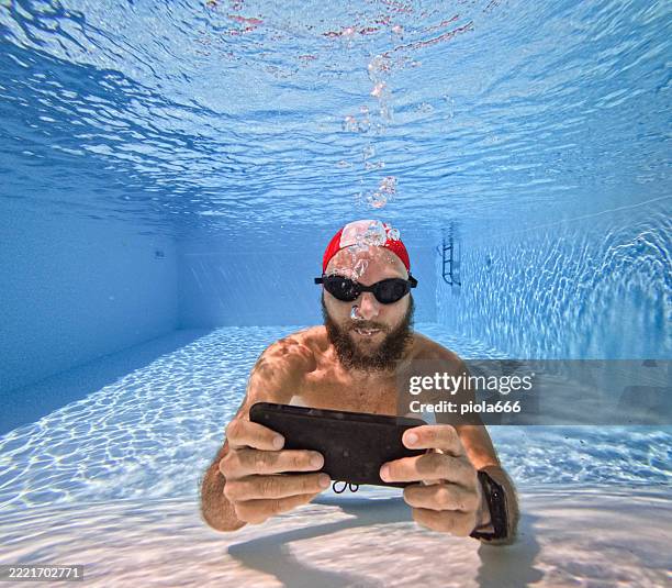 online gaming and gambilng addiction: man using a mobile phone underwater - bid stock pictures, royalty-free photos & images