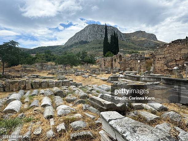 ruins of ancient corinth with acrocorinth mountain in background - apollo creed stock pictures, royalty-free photos & images
