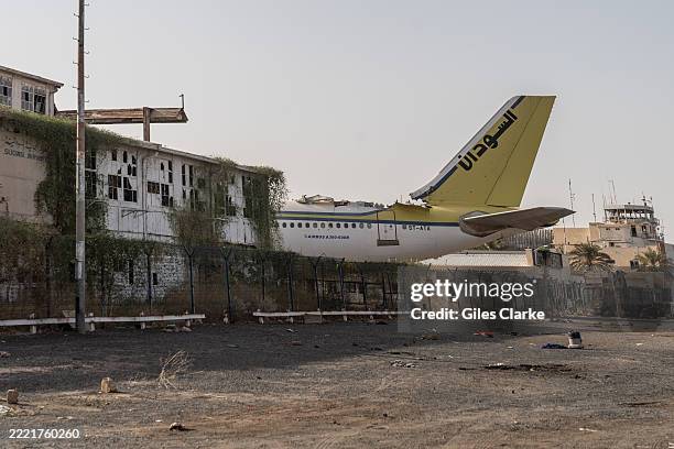 April 26 2025. The damaged tail section of an airliner juts out onto the tarmac area at Khartoum International Airport. Khartoum International...