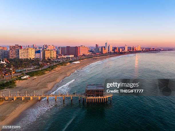 stadtbild von durban am strand bei sonnenaufgang - durban stock-fotos und bilder