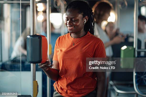 young black woman paying bus fare with smartphone - contactless payment bus stock pictures, royalty-free photos & images