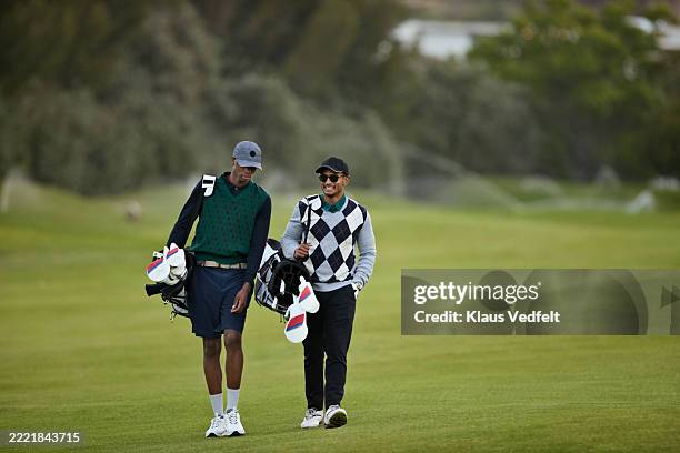friends talking while walking at golf course - golf plaid stock pictures, royalty-free photos & images