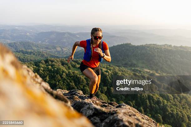 frau läuft in den bergen - querfeldeinlauf stock-fotos und bilder