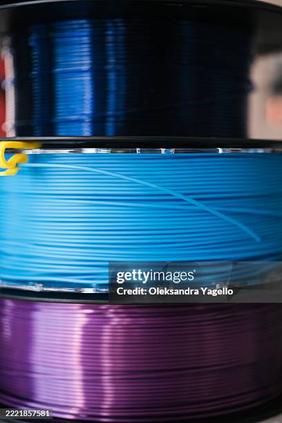 different spools of colorful filament ready for 3d printing projects in a workshop setting - plastic model kit stock pictures, royalty-free photos & images