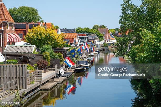canal with dutch flags in appingedam, the netherlands - dutch flag stock pictures, royalty-free photos & images