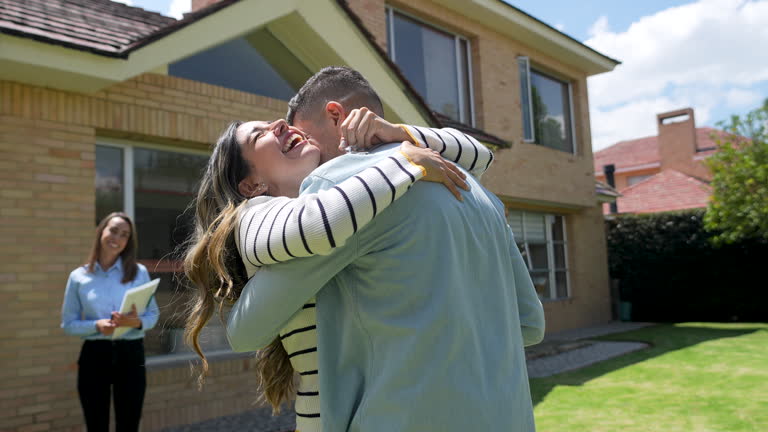 https://media.gettyimages.com/id/2221863567/video/couple-outside-their-new-home-celebrating-with-a-hug-while-real-estate-agent-is-standing-at.jpg?b=1&s=640x640&k=20&c=d0U8bYJae7J6WXQp4bhIzhbwhyac7c7LXy_gSb0ftJE=