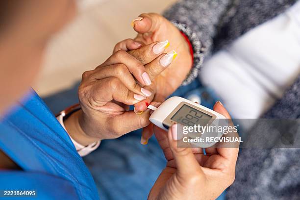 la enfermera a domicilio controla los niveles de glucosa en sangre del paciente anciano. - prevención de enfermedades fotografías e imágenes de stock