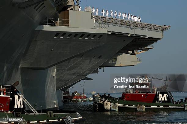 Navy sailors walk along the deck as they prepare for the aircraft carrier USS Gerald R. Ford to depart from the Naval Station Norfolk on June 24 in...