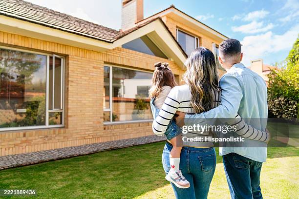 loving family outdoors looking at their new house - mudar de casa imagens e fotografias de stock