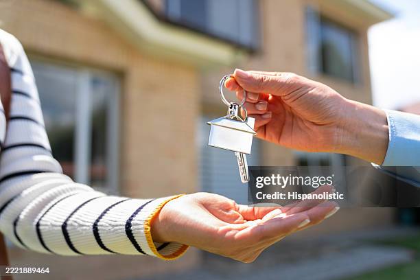 real estate agent giving the keys of their house to a new homeowner - house keys stock pictures, royalty-free photos & images