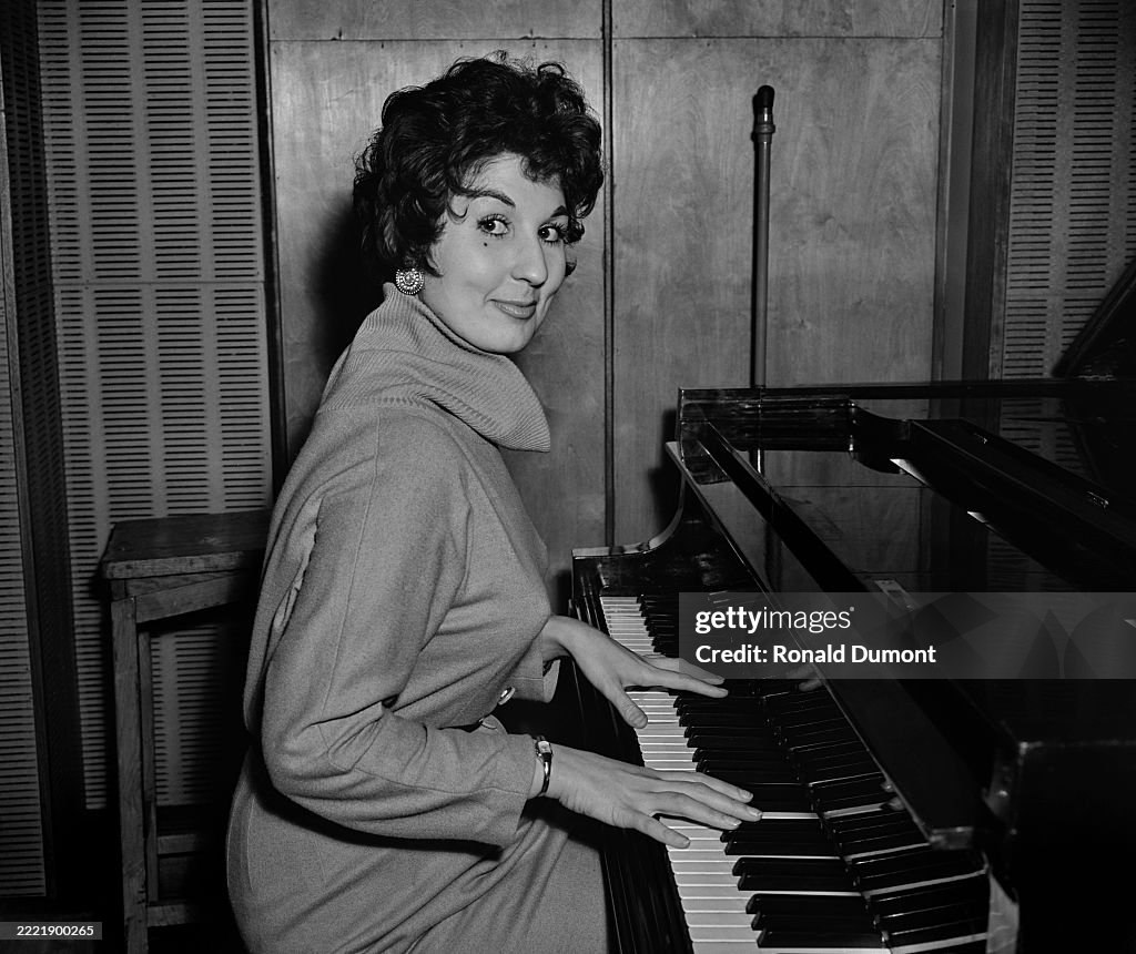 Alan Cogan British singer Alma Cogan, wearing a cowl-neck outfit, playing the ...