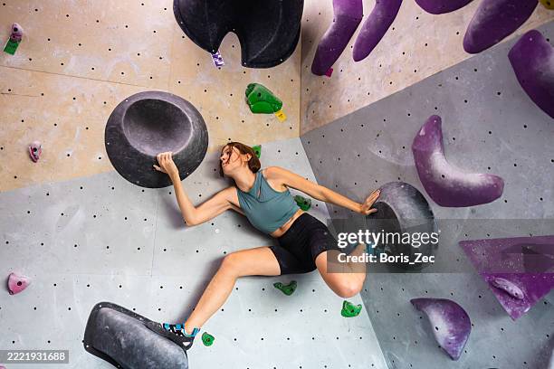 athlete stretching on modern climbing holds - bouldering stock pictures, royalty-free photos & images
