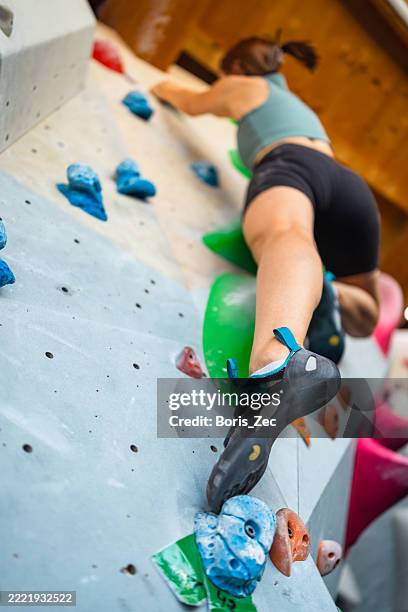 athletic woman rock climbing indoors - low ultra wide angle - sport climbing stock pictures, royalty-free photos & images