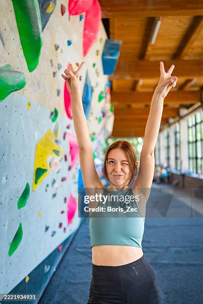 energische kletterin mit erhobenen armen - freiklettern stock-fotos und bilder