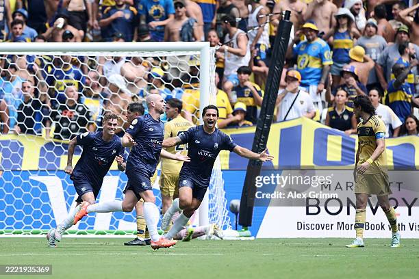 Christian Gray of Auckland City FC celebrates with Myer Bevan and Nikko Boxall after scoring his team's first goal on a header past Agustin Marchesin...