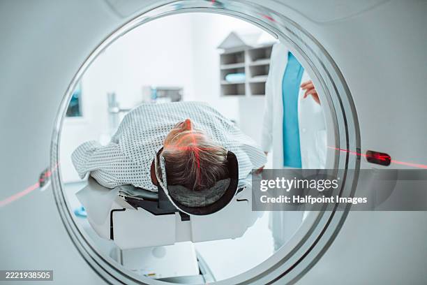 senior woman positioned for head scan with laser alignment in ct scanner. - mri scanner stock pictures, royalty-free photos & images