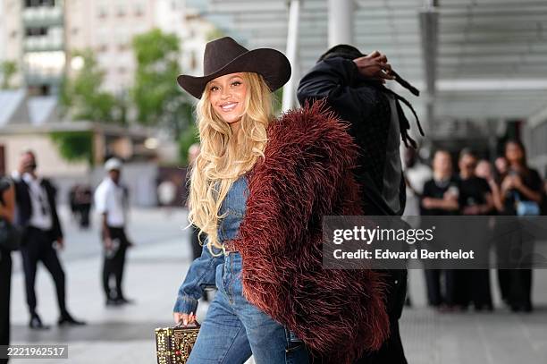 Beyoncé Knowles / Beyonce wears a cowboy hat, a burgundy faux fur fluff coat on one shoulder, a blue denim shirt, during the Louis Vuitton Menswear...
