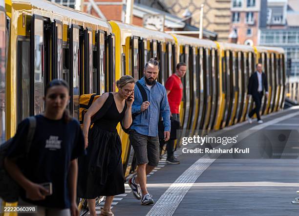 menschen, die eine ankommende u-bahn verlassen - öffentliches verkehrsmittel stock-fotos und bilder