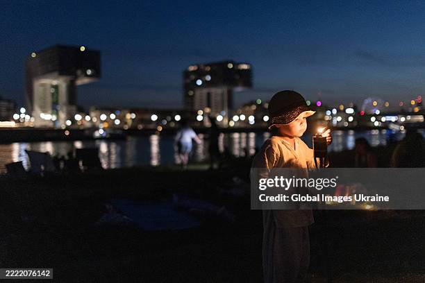 Child lights fire during celebrations by the Ukrainian community Kupala folk holiday on June 21, 2025 in Cologne, Germany.
