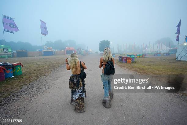 Festivalgoers being their journeys home on a misty morning at the end of the Glastonbury Festival at Worthy Farm in Somerset. Picture date: Monday...
