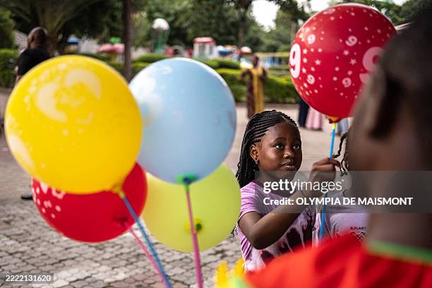 Child picks a balloon from a vendor at Magic Land amusement park in Abuja, on June 29, 2025. In many ways, Nigeria is in crisis, from galloping...