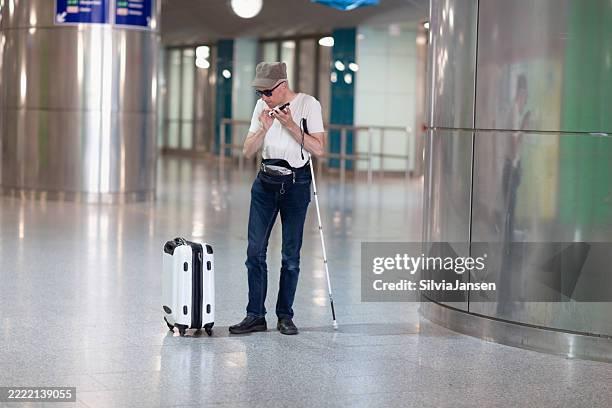 blind man using phone in subway station - cegueira imagens e fotografias de stock