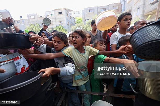 Palestinian children line up to receive a hot meal at a food distribution point in Nuseirat on June 30, 2025. After more than 20 months of...