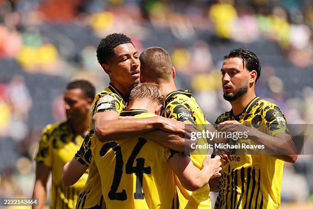 Daniel Svensson of Borussia Dortmund celebrates scoring his team's first goal with Jobe Bellingham, Ramy Bensebaini, and Waldemar Anton during the...