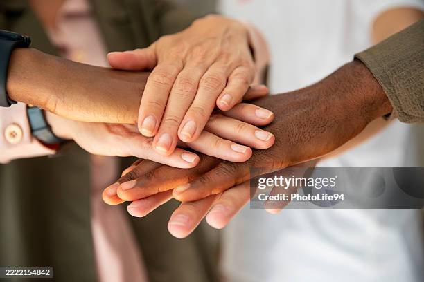 colleagues joining their hands in solidarity - handen ineengevouwen stockfoto's en -beelden