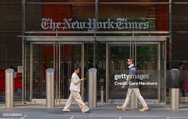 People walk past the front door of The New York Times headquarters on 8th Avenue on June 24 in New York City.