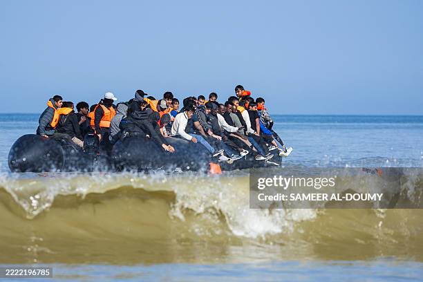 Migrants board a smuggler's boat in an attempt to cross the English Channel off the beach of Hardelot in Neufchatel-Hardelot, northern France on June...