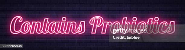 contains probiotics - glowing neon text on brick wall background - probiotic stock illustrations