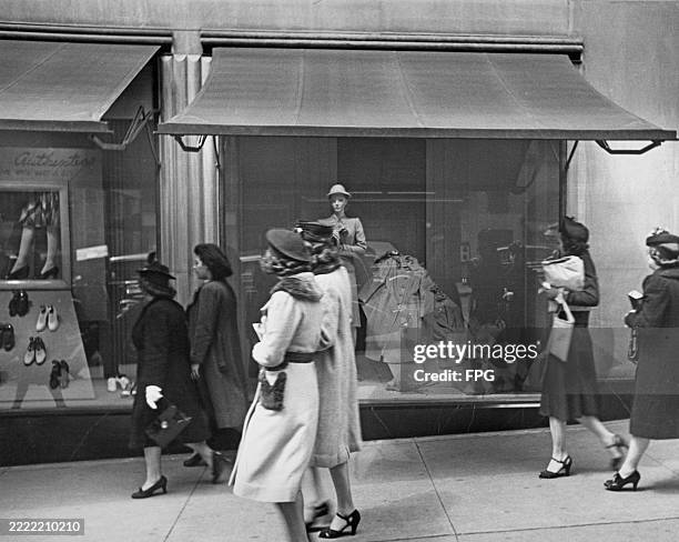 Women passing the shop windows of Saks luxury department store on Fifth Avenue, New York, 1950s.