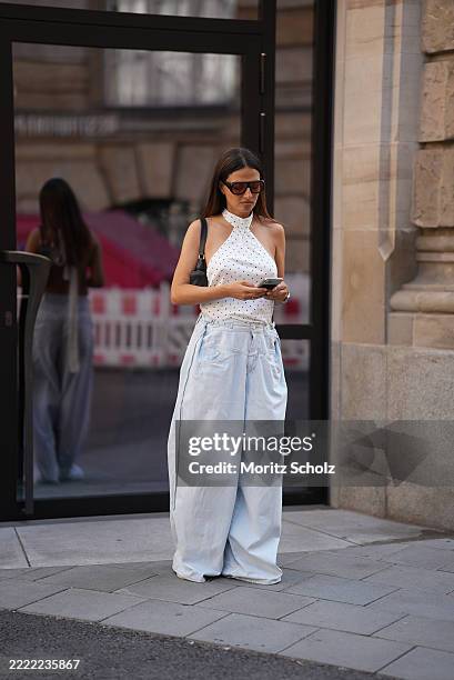 Anna Winter is seen wearing an off-white and black Polkadot Enya mini dress with scarf tie detail at the neck worn as a top from Jaded London; a...