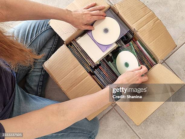 aerial view of person looking into a box full of compact discs storage media in a box - compact disc stock pictures, royalty-free photos & images