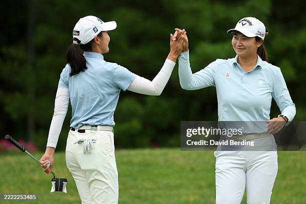 Yahui Zhang and Yan Liu of China high five after a putt on the fifth during the first round of the Dow Championship 2025 at Midland Country Club on...