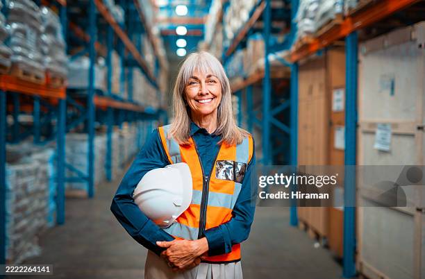 smiling senior woman in a logistics warehouse wearing safety gear - hierarquia de corporação imagens e fotografias de stock