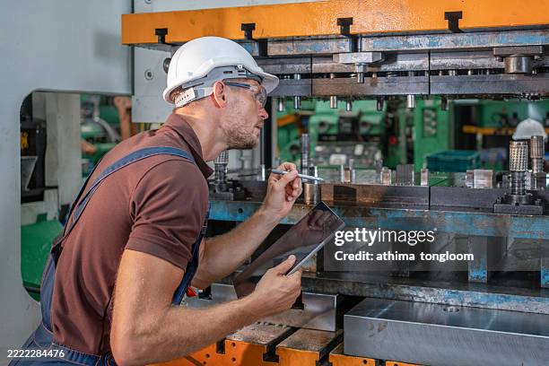 factory worker is programming a cnc milling machine with a tablet computer. - manual worker milling machine operator photos et images de collection
