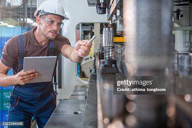 factory worker is programming a cnc milling machine with a tablet computer. - manual worker milling machine operator photos et images de collection