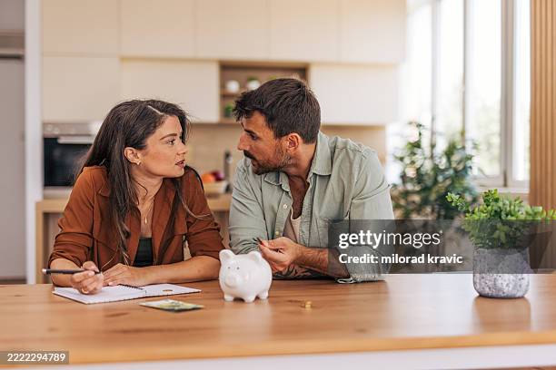 worried couple discussing finances at home, managing home budget - verkligt par bildbanksfoton och bilder